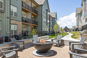 an outdoor area with a fire pit in front of an apartment building at Upland Flats, Colorado, 80922